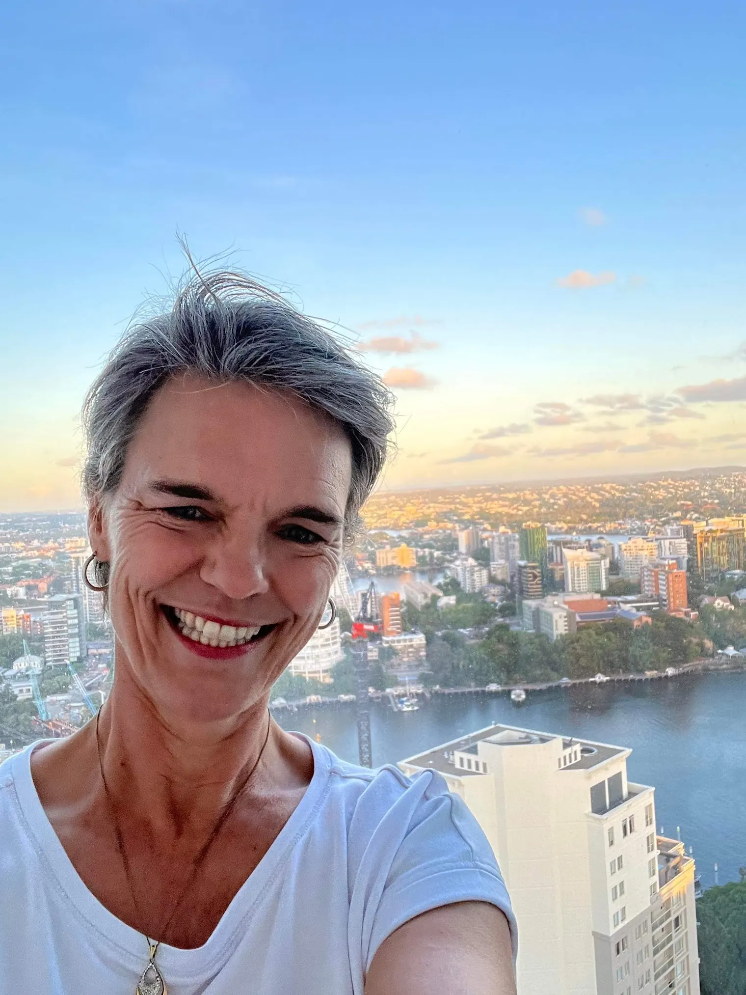 Ivanka Menken smiling above the Brisbane River at sunset